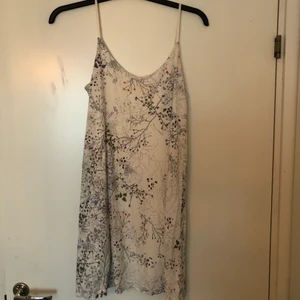 Kort klänning  - Blommig avslappnad klänning. Den är i storlek S och har justerbara band. Den sitter löst och är kort. Köparen står för frakten.