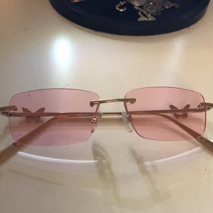 Fjärilsolglasögon säljes!  - Säljer ett par nya, rosa solglasögon med fjärilar på sidan av. Köptes för några veckor sen, säljer p.g.a inte min stil längre