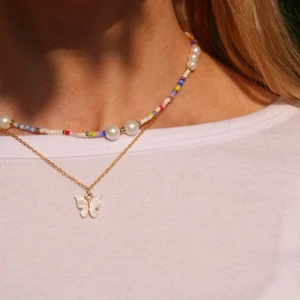 Pärlhalsband  - Multifärgat pärlhalsband som går att spänna ut till 45 cm och in till 40cm.fjärilshalsbandet ingår ej!😊