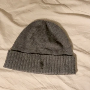 Polo Ralph Lauren mössa - Säljer min gråa Ralph Lauren mössa då den inte används. Haft i ca 1 år men inte använd mer än 3 ggr och tvättats sedan senaste användning. 