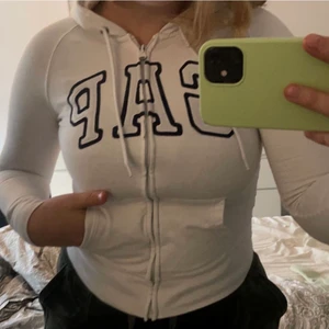 GAP zip hoodie - Super fin GAP zip hoodie! 💕 Säljer då jag växt ur den. Finns en liten fläck vid lappen inuti hoodien (se bild 2) & så har färgen på dragkedjan börjat lossna (se bild 3) annars super fin! Väldigt sann i storleken XS. Ny pris 370kr. Vid flera intressen skapas en budgivning!