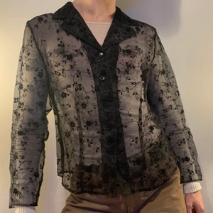 Svart vintage mesh kavaj sammet blommor - Svart vintage mesh kavaj med små glittriga sammetsblommor, 5 knappar på framsidan och sömmar som gör passformen ännu bättre 🖤 Denna kavajen ger sånna 90-tals vibes och är så snygg att slänga på vilken outfit som helst för att lägga till små detaljer med glittret, blommorna och de olika materialen! Den är också perfekt för att klä upp en outfit och det bästa är att man fortfarande kan se resten av outfiten under!