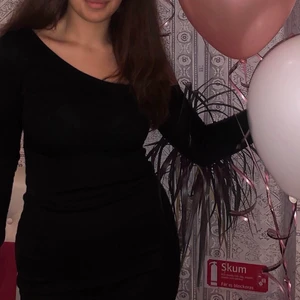 Svart lång ribbad klänning med detalj - Knälång ribbad one shoulder klänning med en sleeve detalj. Köpt för 220kr och använt en gång.