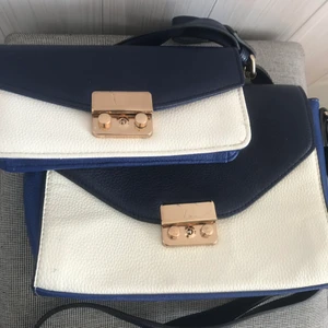 Handväska  - Två handväskor från Åhlens! Säljes var för sig eller båda tillsammans. Den stora säljer jag för 70 kr och den lilla för 50 eller båda två för 100. Väldigt fina och använda endast någon enstaka gång. Jag skickar gärna fler bilder eller svarar på frågor så tveka inte på att höra av dig om du är intresserad! ☀️ Jag räknar med 66 kr i frakt men ska försöka få ner den kostnaden vid intresse. Annars så kan jag mötas upp i Stockholms innerstad eller Värmdö beroende på vad vi kommer överens om. 😊