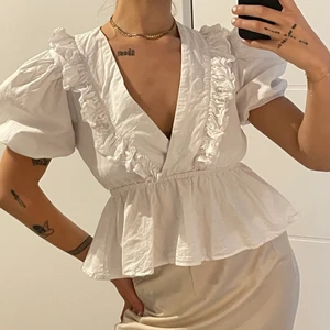 Vit topp med volanger  - Säljer denna vita topp från Boohoo. Säljes pga alldeles för stor. Har man större bröst tror jag denna toppen passar super bra. Mina är alldeles för små för att de ska se bra ut i denna toppen. Volangerna är ej strykta. Stryker man dem ser dem mycket finare ut. Fraktskostand tillkommer⚡️🦋