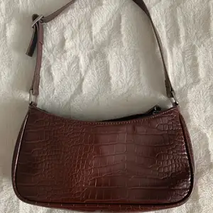 Super fin brun väska med ormskinns mönster. Köpt från monki. Använd få gånger, säljer pga att den inte används. Köpare står för frakt.💗