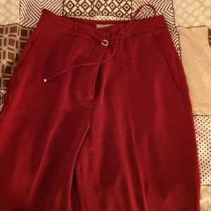 Kostym byxor  - Otroligt fina kostym byxor i röd färg från hm. Byxorna är aldrig använda, enbart legat i garderob. Säljes då jag inte kommer i dessa byxor. 