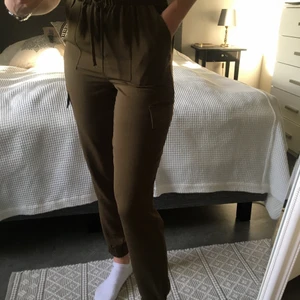 Kakigröna byxor - Kakigröna tunna byxor med fickor på höften och benen. Resår och knytning i midjan. Storlek S. Jag har innerbensläng 86cm därav lite korta byxben på mig👖