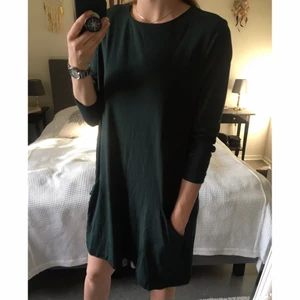 Mörkgrön klänning - Mörkgrön löst hängande klänning. Medeltjockt tyg. Fickor på nedre framsidan. Trekvartslånga ärmar 👗