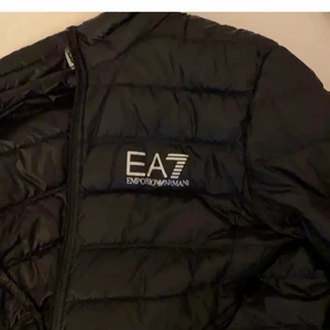 EA7 jacka - Säljer en svart Emporio armani jacka som är köpt från NK här i Stockholm (Nordiska kompaniet) och den är äkta. Jackan köptes för mer än 1300 kr och har ingen luva. Köpare står för frakt.  Bud börjar på 360 kr. Kontakta vid frågor/intresse.  