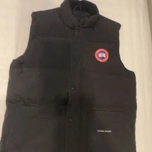 Canada goose väst  - Svart canada goose väst i stl M kill modell. Som ny bara att den Har ett litet hål som knappast märks som ni kan se på sista bilden. Kvitto och äktenhetsbevis finns. Använd en vår köpt åt 2020 Bara höra av sig om ni är intresserade så kan priset diskuteras vid snabb affär. Nypris:4700