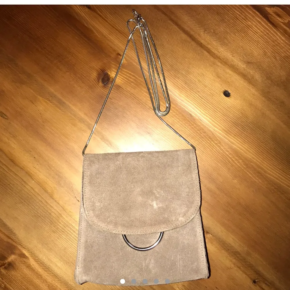 Suede shoulder bag with adjustable silver snake chain strap, magnetic flap closure and a silver chain decoration underneath the flap. Sold out!  Measurements: 6.5