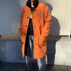 Vändbar jacka  - En jacka som en kan ha på två sätt, antingen med den orangea sidan utåt eller den svarta. Använd en gång.