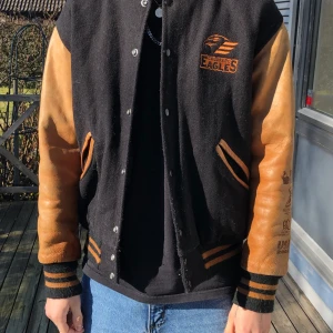 Baseballjacka - Baseballjacka med märke från ishockeyklubben Colorado eagels. Har okänd signatur på vänster ärm.