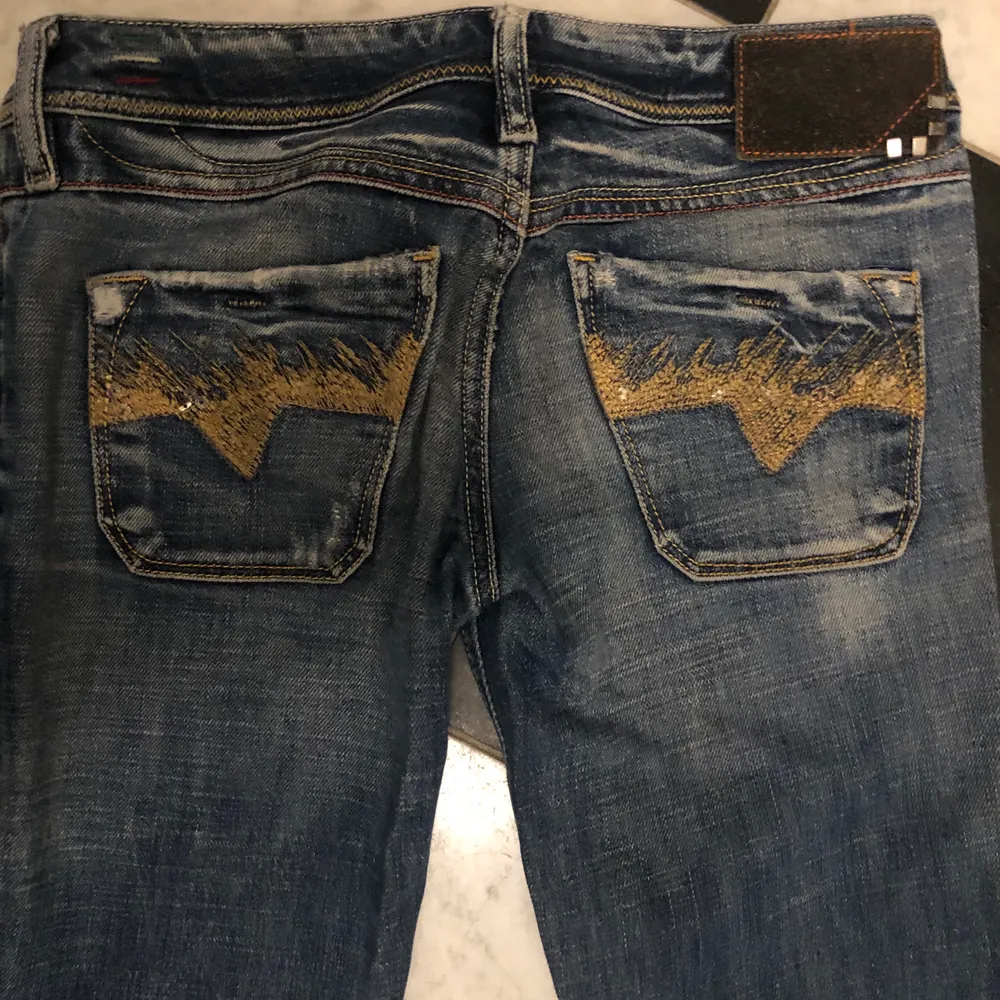 Lågmidjade jeans från Diesel. Raka i modellen med coola guldiga detaljer på fickorna. Storlek 25/32. Har lite slitningar nertill, men annars bra skick, köpta second hand. Säljer för att dem inte kommer så mycket till användning. Buda från 80kr!!💞. Jeans & Byxor.