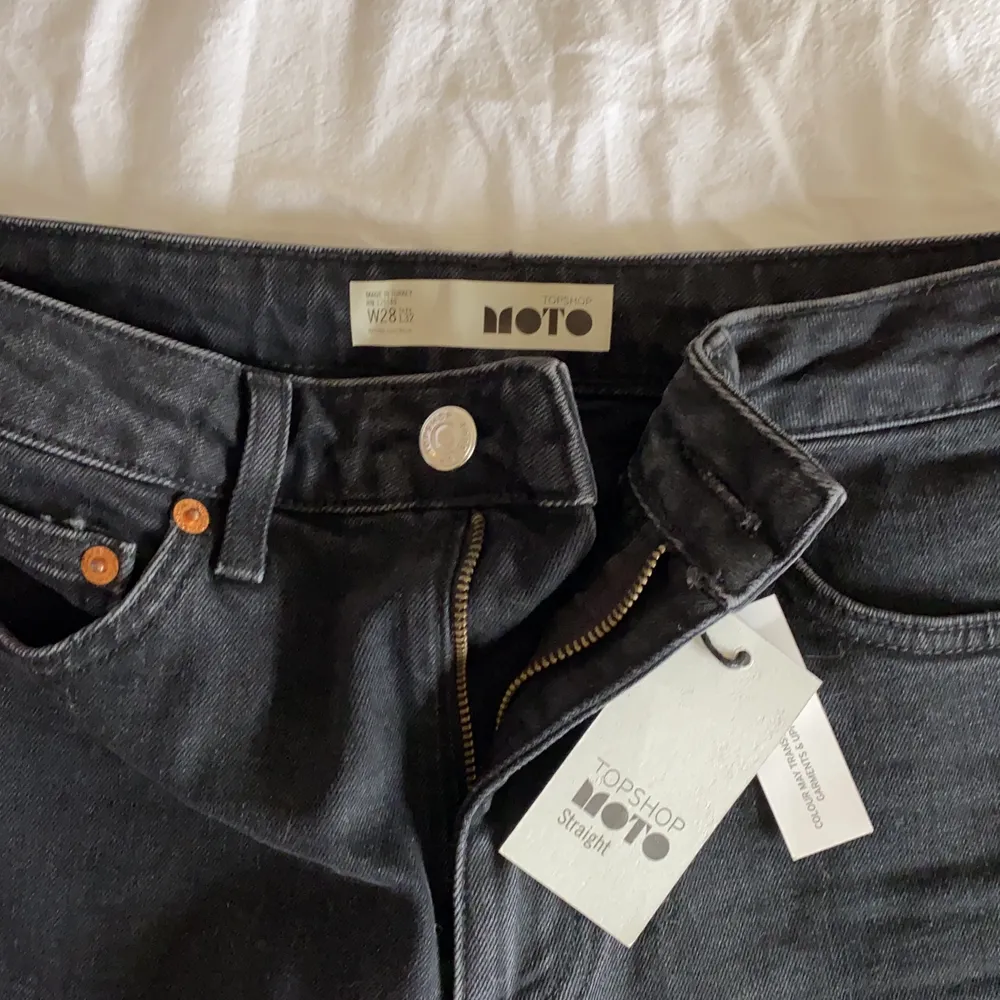 Oanvända jeans med croppade ben, Topshop, grå/svarta med slitningar vid byxbenet slut. Rak modell. . Jeans & Byxor.