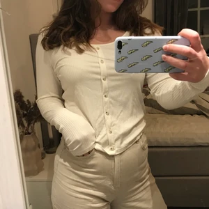 Vit ribbad tröja.  - Jättefin vit ribbad tröja med liten u- ringning från H&M🥰. Säljs pga den inte kommer till användning. Bra skick, inte använd mycket. Knappar framtill, inte genomskinlig. 
