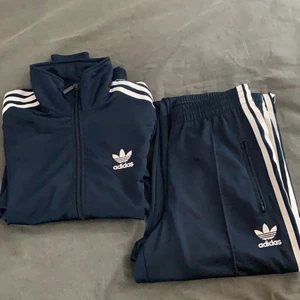 Adidas trucksuit - As ball adidas tricksuit i marin blå färg, väldigt sparsamt använt. storlek S i tröjan och m i byxorna men passar en S 🤎✨