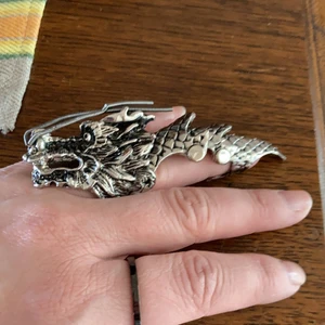Sjukt maffig ring goth  - Sjuk snygg ring i from av en drake. Sitter bra på mitt ringfinger där jag har 17 mm annars. Såå cool. Trasig i ena gångjärnet se bild men inget som stör. Går att laga för den händige. Frakt tillkommer 25kr