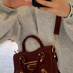 Röd Balenciaga Väska - En helt oanvänd, äkta ”Balenciaga mini city bag” i vinröd färg. Guld-detaljer. Säljs inte längre så därför väldigt unik och cool. Köpt för ca 15 000 kr, säljer för 8 000 kr från start. Kontakta mig om ni är intresserade. 