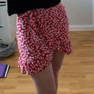 Blommig omlott kjol  - Fin somrig kjol, rödvit blommig  stolek M men skulle snarare säga att det är en S men skulle kunna passa XS oxå - köparen står för frakten - pris går att diskutera 