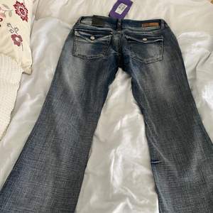 Säljer dessa lågmidjade jeans från Fuga Denim. De är köpta vintage men är helt oanvända och har kvar alla orginalprislappar. De är lite mindre i storlek och är gjorda av hårt denim. Jättesnygga detaljer på bakfickorna samt framfickorna. Skriv för mer bilder💓