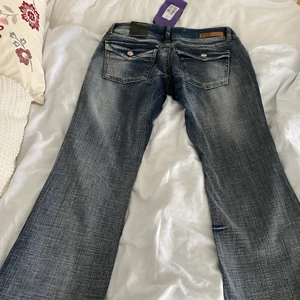 Lågmidjade jeans - Säljer dessa lågmidjade jeans från Fuga Denim. De är köpta vintage men är helt oanvända och har kvar alla orginalprislappar. De är lite mindre i storlek och är gjorda av hårt denim. Jättesnygga detaljer på bakfickorna samt framfickorna. Skriv för mer bilder💓