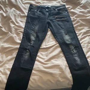 Nya Blavk premium Jeans  strl W27L32 - Oanvända Black premium jeans från EMP. Strl W27 L32. Sliten stil fram samt på fickorna bak. Stretchmaterial, låg midja. 