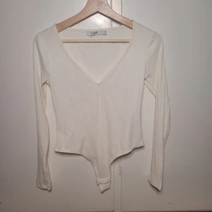 Vit ribbad body - Body från nakd. V urringad. Aldrig använd