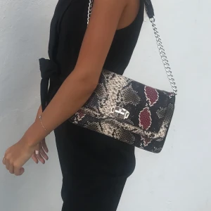 Väska  - Jag säljer min ormskinnsindpererade väska med silver detaljer. 