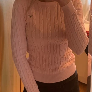 Ljusrosa stickad Gant tröja  - Gant flätstickad rundhalsad bomullströja med stretch i färgen ljusrosa, storlek XS (köparen betalar frakten) Säljer den pga att den är för liten