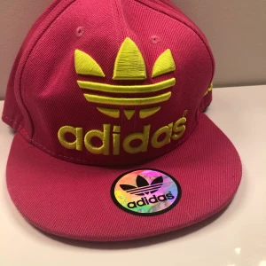 Adidas keps - Säljer en rosa adidas keps i ett väldigt fint skick🤍vet inte storlek men det finns knappt så man kan spänna in och spänna ut den