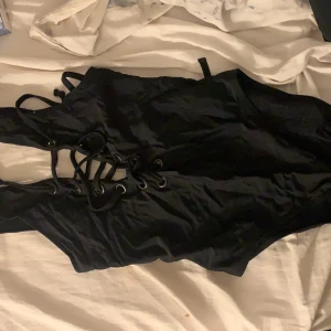 Baddräkt med snörning  - Svart Baddräkt med snörning både bak och fram st XS från Bik bok använd 1 gång.