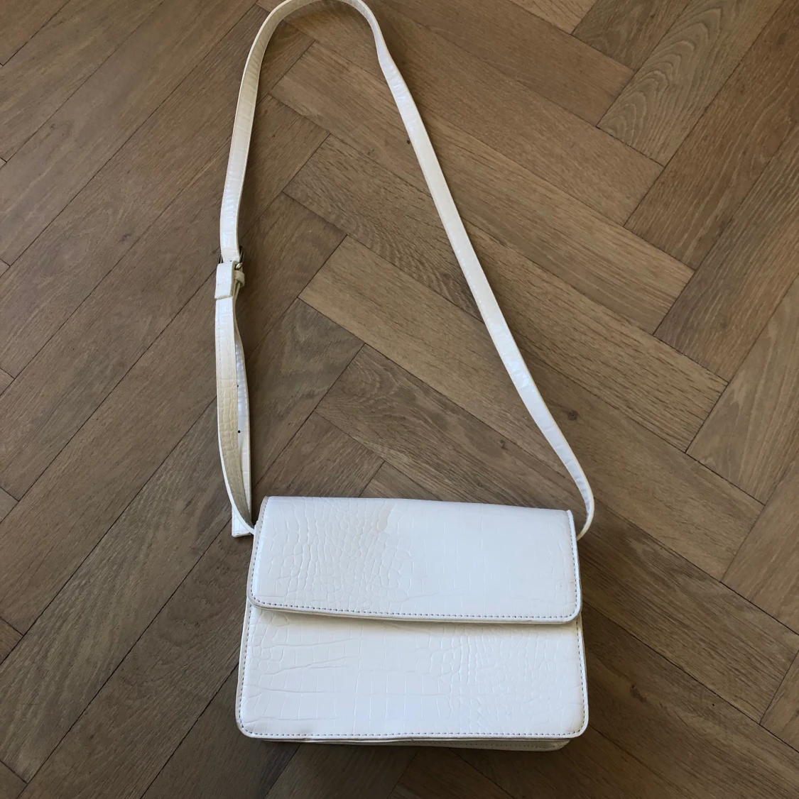 Vit axelremsväska 