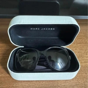 Svarta solglasögon från Marc Jacobs - Snygga svarta solglasögon från Marc Jacobs med stora, fyrkantiga bågar och mörka glas. Kommer med originalfodral i vitt. I bra skick.