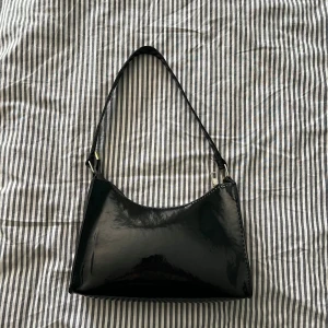 Svart väska - Svart handväska i använt men fortfarande fint skick utan hål eller fläckar. Dragkedjan kan vara lite smått krånglig att stänga men det funkar. Köp gärna bundle och få extra rabatt, jag behöver bli av med allt!