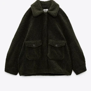 Mörkgrön teddyjacka från Zara - Säljer en oversized mörkgrön teddyjacka från Zara med stora fickor framtill och klassisk krage. Jackan har en fluffig och mjuk känsla, perfekt för kyliga dagar. Stängs med knappar och har en avslappnad passform som ger en härlig känsla😊skriv för fler bilder vid intresse🌟
