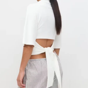 Vit croppad topp med knyt i ryggen - Knyttröja från Gina tricot. Aldrig använd, tror tom att lappen sitter kvar💞 nypris: 299! 