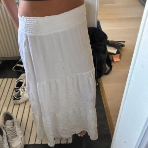 Vit långkjol  - Säljer en flowy vit långkjol. Kjolen är i tunt, lätt tyg och har en avslappnad passform. Perfekt för varma dagar och enkel att styla med crop tops eller linnen. Ej strykt på bilderna, självklart lite finare strykt! ❣️