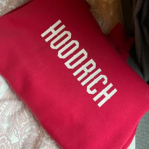Röd HOODRICH hoodie XS - Snygg röd hoodie från HOODRICH i storlek XS. Tröjan har vit logga tryckt framtill. Köpte här på plick och har använt den typ två gånger sen dess då jag inte riktigt tycker röd är min färg, inget fel på den förutom att domhär sakerna som ska sitta på snörena har ramlat av, kan absolut diskutera priset!🙂🩷