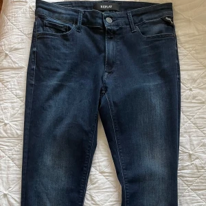 Mörkblå Replay jeans slim fit - Snygga mörkblå jeans från Replay med klassisk design och diskret tvättade detaljer. Jeansen har slim passform och raka ben,  i stretchigt jeansmaterial för extra komfort. Är i strl W31 L30, I nyskick