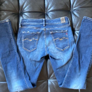 Blå Replay jeans skinny fit - Snygga blå jeans från Replay med skinny passform och klassiska detaljer. Jeansen har normal midja, fem fickor och gul kontrastsöm. Materialet är stretchigt jeans för en bekväm känsla. Perfekta till sneakers eller boots.