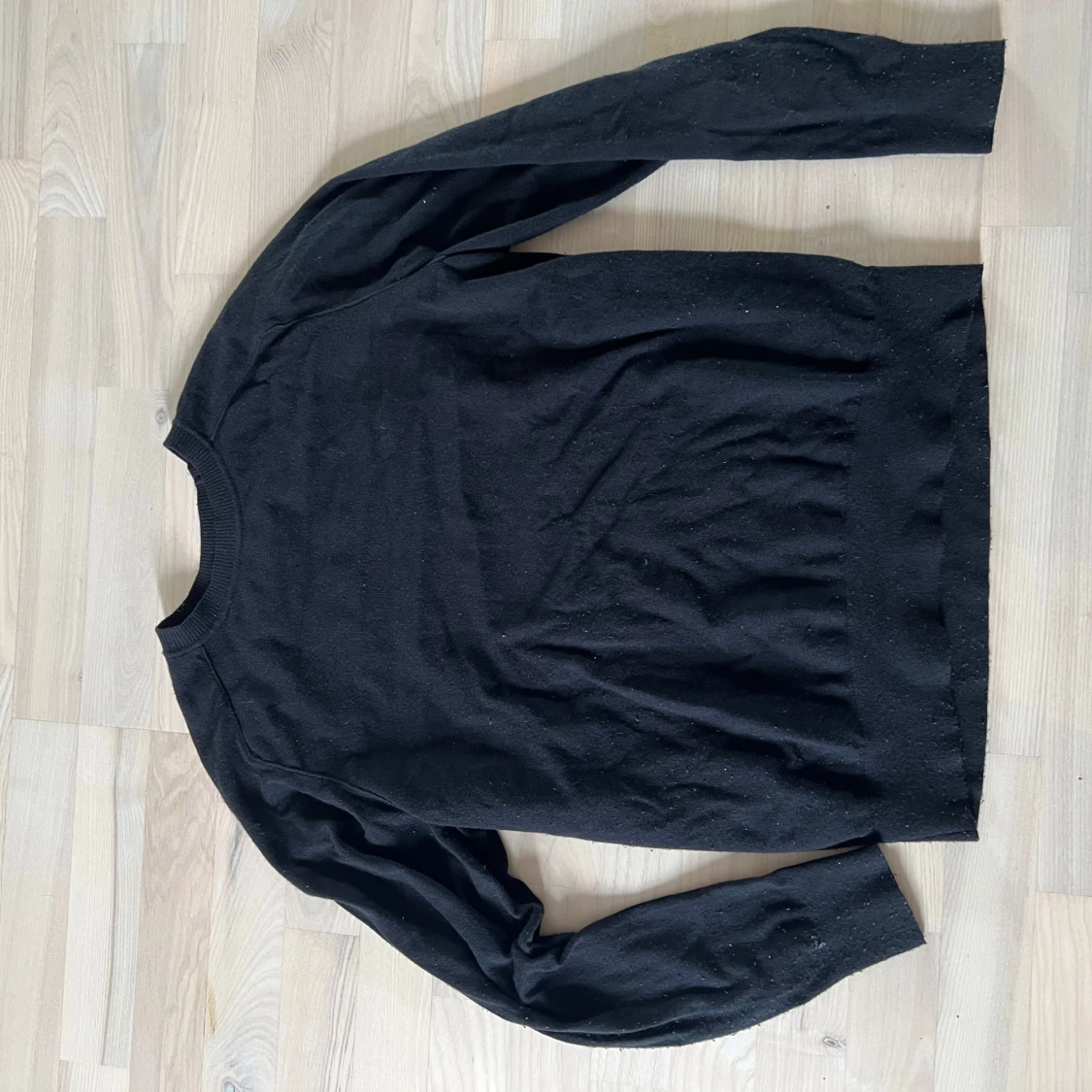 Svart stickad tröja med diskret logga