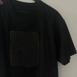 Svart t-shirt från Limitato med print - Svart t-shirt från Limitato med coolt svart print framtill som har en grafisk design. Klassisk rund hals och korta ärmar. T-shirten är i mjuk bomull och har en stilren look med diskret logga bak i nacken. Svår att få tag på!