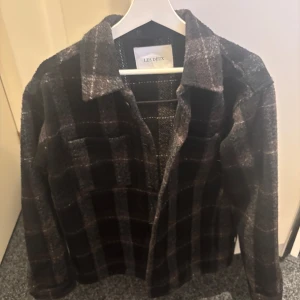 Overshirt från Les Deux - Rutig svart/mörkgrön overshirt från Les Deux. Storlek M passar dig mellan 180-185 cm. Aldrig använd endast testad sedan har den bara hängt i garderoben. Köpt på mq för 1500.