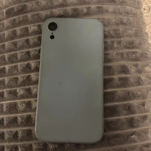 Grått mobilskal till iPhone XR - Säljer ett stilrent grått mobilskal till iPhone XR. Skalet är gjort i mjuk syntet och har en matt finish. Det har exakta utskärningar för kamera, knappar och laddningsport. Perfekt för dig som vill ha ett enkelt och clean skydd till mobilen. Lite smutsig på vissa delar men inte så mycket.