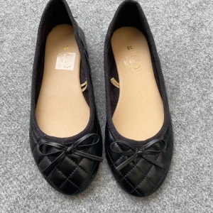Svarta ballerinaskor - Helt nya stilrena svarta ballerinaskor med söt rosettdetalj framtill. Perfekta för dig som gillar klassisk och enkel stil. Storlek 38