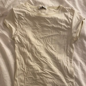 Pastel gul T-shirt från Zara - Enkel och stilren pastel gul t-shirt från Zara i storlek S. T-shirten har korta ärmar, rund halsringning och är tillverkad i ett mjukt, tunt material som känns skönt mot huden. Perfekt att matcha med jeans eller kjol för en clean look.