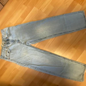 Ljusblå baggy jeans - Säljer ett par supersnygga ljusblå baggy jeans från lager 157 då dom ej kommer till användning längre. Jeansen är i storlek XS Short. Jeansen har raka ben och knappgylf. . Materialet är klassisk denim i bomull. Den enda defekten är en fläck på baksidan av jeansen vid fötterna, men det borde gå bort i tvätten om man behandlar dom. Är 164cm o dom är bra i längden. Originalpris: 400kr