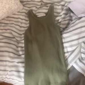 Olivgrön ribatt linne från KappAhl - Ett olivgrönt linne i storlek 134-140